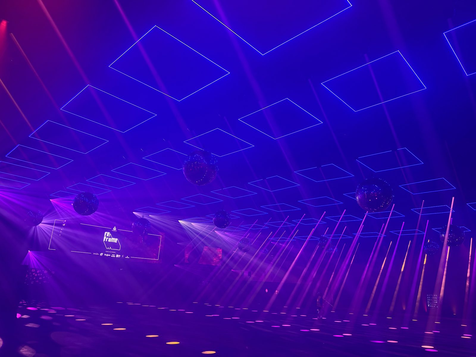 Light beams and kinetic squares filling the room at RE:FRAME