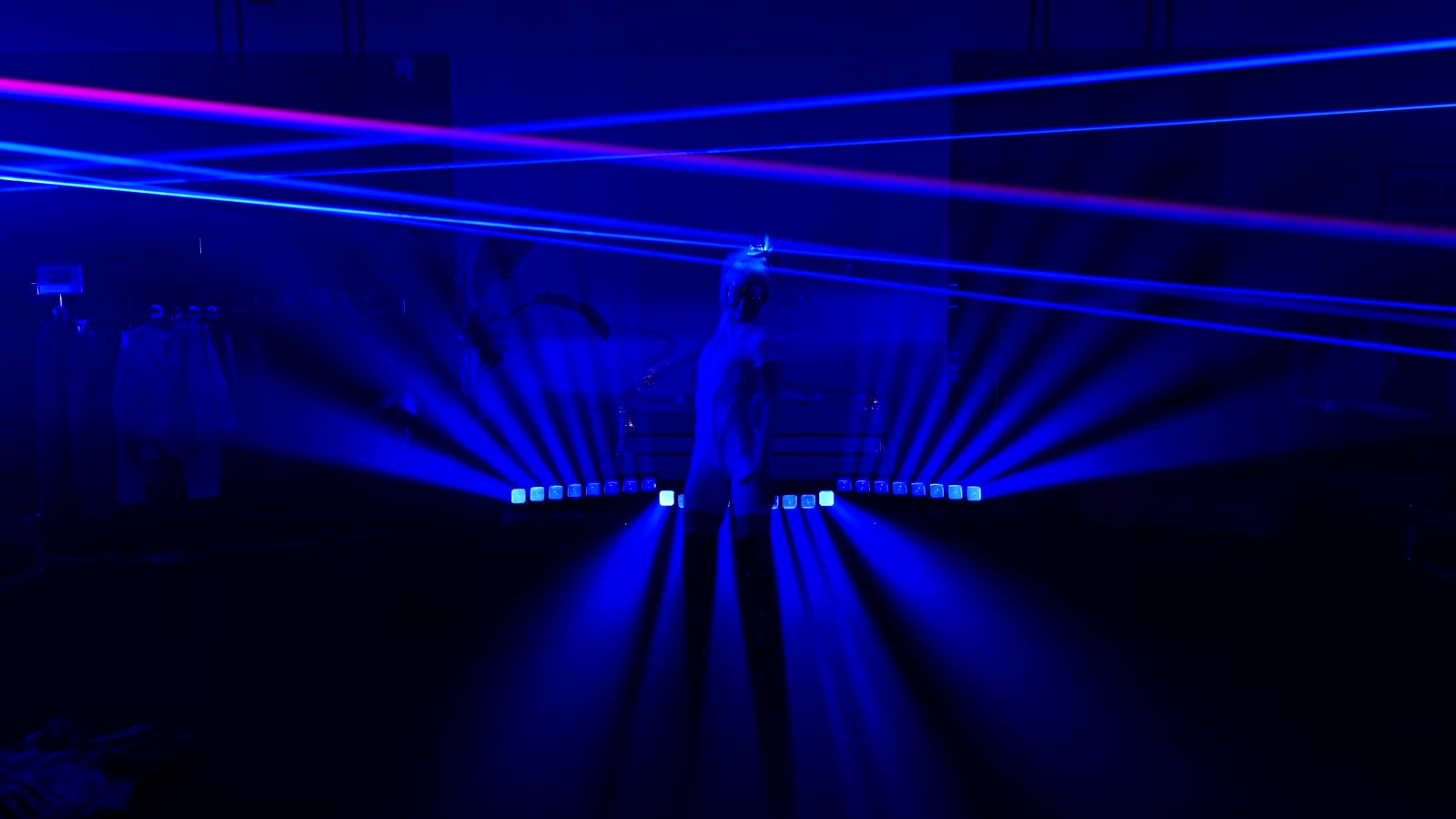 Night Pulse laser show — blue beams cutting across an after-hours retail space